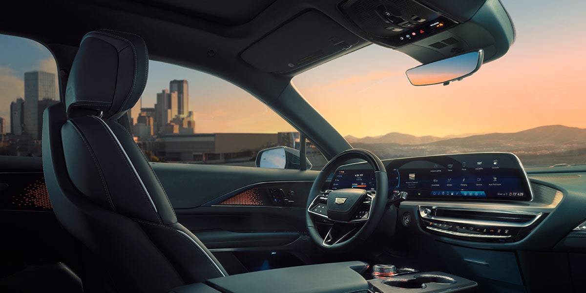 Passenger View of the Driver's Side of the 2025 Cadillac LYRIQ Outlooking a City During a Sunset