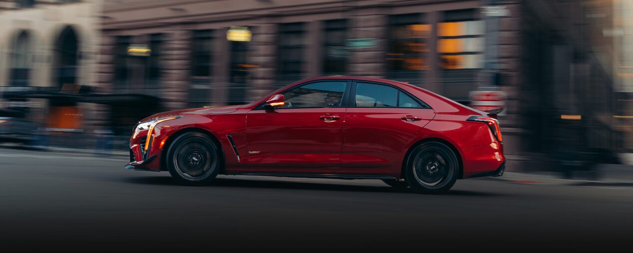 The Side Profile of a Red Cadillac CT4-V Driving Through Downtown