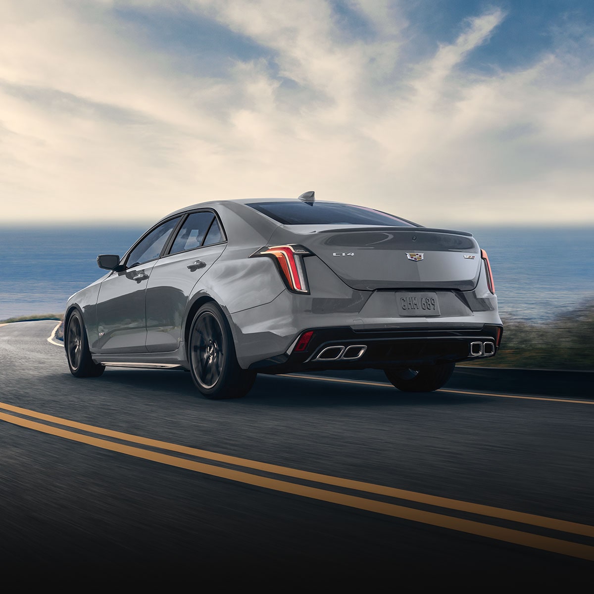 A Rear View of a CT4-V Driving Down a Highway with an Ocean View in Front
