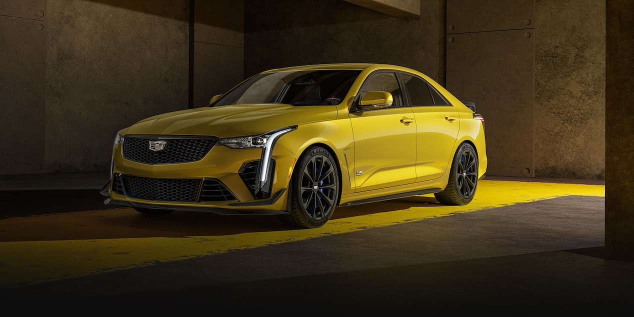 A Yellow Cadillac CT4-V Blackwing Parked on Top of a Strip of Yellow Paint Inside a Building.