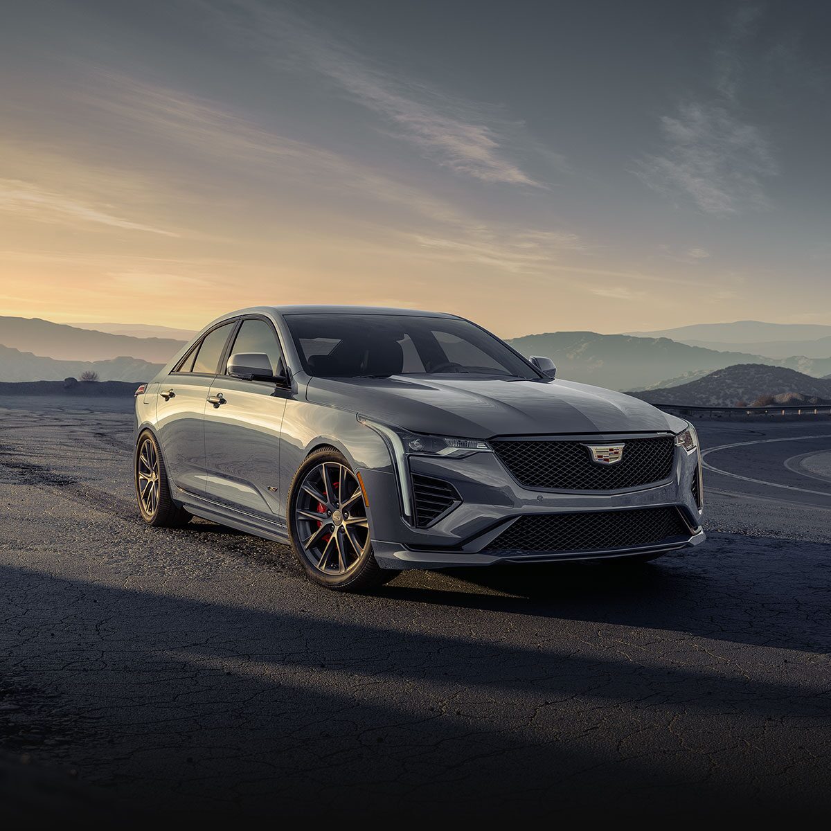 Three-quarter View of a Silver 2024 Cadillac CT4-V Parked on the Side of a Mountain Road